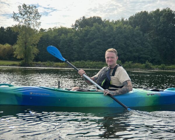 Community member kayaking on the lake