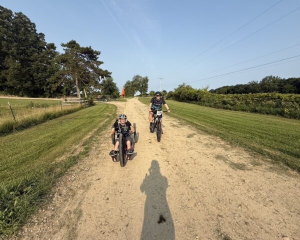 Adaptive hand cyclists riding through countryside trails